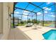 Inviting pool area with outdoor seating and a spacious screened-in enclosure, providing serene outdoor enjoyment at 11215 Se 172Nd Place, Summerfield, FL 34491