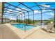 Screened-in pool area with a relaxing atmosphere and scenic views of the lake at 11215 Se 172Nd Place, Summerfield, FL 34491