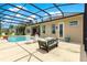 Outdoor screened-in lanai with a beautiful in-ground pool and comfortable seating area at 11215 Se 172Nd Place, Summerfield, FL 34491