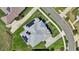 A drone's eye-view shows a modern house, emphasizing roof design and solar panel placement at 1127 Fiesta Key Cir, Lady Lake, FL 32159