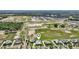 Expansive aerial view of planned community surrounded by trees and green space with a property marker at 1127 Fiesta Key Cir, Lady Lake, FL 32159