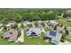 A drone's eye-view shows multiple homes are equipped with solar panels in a wooded area at 1127 Fiesta Key Cir, Lady Lake, FL 32159