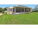A well-maintained backyard features a screen enclosed patio and lush green lawn at 1127 Fiesta Key Cir, Lady Lake, FL 32159