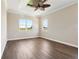 Bedroom with wood flooring, fan, and large windows showcasing the outdoor view at 1127 Fiesta Key Cir, Lady Lake, FL 32159
