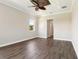 Bedroom with tray ceilings, wood flooring, view to bath and large windows at 1127 Fiesta Key Cir, Lady Lake, FL 32159