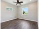 Bright bedroom featuring wood flooring, a ceiling fan, and natural light from two windows at 1127 Fiesta Key Cir, Lady Lake, FL 32159