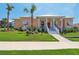 Charming peach-colored home with a welcoming front porch and beautifully landscaped yard at 1127 Fiesta Key Cir, Lady Lake, FL 32159