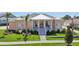 Charming single-story home boasts a welcoming front porch, landscaped yard, and colorful facade at 1127 Fiesta Key Cir, Lady Lake, FL 32159