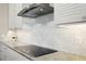A modern kitchen countertop with light cabinets, tile backsplash, and stainless steel appliances at 1127 Fiesta Key Cir, Lady Lake, FL 32159