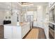 Bright kitchen with a large island, white cabinets, stainless steel appliances, and modern lighting at 1127 Fiesta Key Cir, Lady Lake, FL 32159