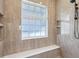 Beautiful shower with bench, rainfall shower head, marble tile, and built-in shelving niche at 1127 Fiesta Key Cir, Lady Lake, FL 32159