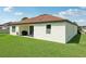 Well maintained exterior featuring a covered patio and a large grassy backyard at 11313 Little Nellie Dr, Clermont, FL 34711