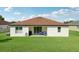 Charming backyard featuring a patio area with lounge seating, lush lawn and well maintained exterior at 11313 Little Nellie Dr, Clermont, FL 34711