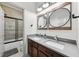 Modern bathroom featuring a double sink vanity, grey countertops, and a glass shower with black trim at 11313 Little Nellie Dr, Clermont, FL 34711