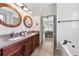 Bathroom featuring dual sinks, wooden framed mirrors, modern fixtures and bright lighting at 11313 Little Nellie Dr, Clermont, FL 34711