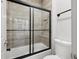 Bright bathroom featuring modern tile, glass shower doors, and a sleek black towel bar at 11313 Little Nellie Dr, Clermont, FL 34711