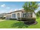 Beautifully landscaped home exterior featuring a well-maintained lawn, mature trees, and elegant architectural features at 11313 Little Nellie Dr, Clermont, FL 34711