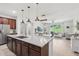 Well-lit kitchen with a large island, stylish pendant lighting, and an open layout to the living area at 11313 Little Nellie Dr, Clermont, FL 34711