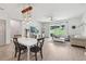 Bright living and dining area with contemporary lighting, wood floors, and sliding doors to the backyard patio at 11313 Little Nellie Dr, Clermont, FL 34711