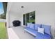 Relaxing covered patio featuring a comfortable cushioned couch and a grill at 11313 Little Nellie Dr, Clermont, FL 34711