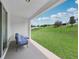 Covered patio area with a comfy blue cushioned lounge set overlooking a well-manicured lawn at 11313 Little Nellie Dr, Clermont, FL 34711