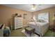 Cozy bedroom with white metal bedframe, complemented by neutral walls and a ceiling fan for added comfort at 11495 Se 71St Terrace Rd, Morriston, FL 32668