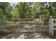 Gated entrance leading to a serene property with lush greenery at 11495 Se 71St Terrace Rd, Morriston, FL 32668