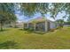Beautiful backyard view showcasing the screened lanai and well-maintained landscaping at 11601 Thacker Dr, Clermont, FL 34711