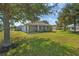 Spacious backyard with a well-kept lawn and a comfortable screened-in lanai at 11601 Thacker Dr, Clermont, FL 34711