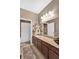 Bathroom featuring a long vanity with granite countertops and decorative signs on the wall at 11601 Thacker Dr, Clermont, FL 34711