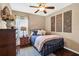Bedroom featuring an iron bed, ceiling fan, dark wood floors, and floral decor at 11601 Thacker Dr, Clermont, FL 34711