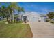 Charming single-story home with a well-manicured lawn, stone accents, three-car garage, and beautiful landscaping at 11601 Thacker Dr, Clermont, FL 34711