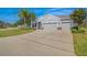 Charming single-story home with a well-manicured lawn, mature trees, three-car garage, and a long driveway at 11601 Thacker Dr, Clermont, FL 34711