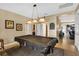 Bright game room featuring a vintage-style billiard table under unique pendant lighting fixture at 11601 Thacker Dr, Clermont, FL 34711