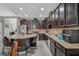 Modern kitchen featuring stainless steel appliances, granite countertops, dark cabinets, and bar seating at 11601 Thacker Dr, Clermont, FL 34711