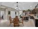 Open kitchen and dining area featuring dark cabinets, stainless steel appliances, an island, and a dining table at 11601 Thacker Dr, Clermont, FL 34711