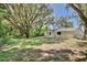 Green backyard with mature tree shading the home's exterior at 1228 Padgett Cir, Lady Lake, FL 32159