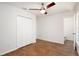 Bedroom featuring wood-look tile flooring, ceiling fan, a closet, and a view into the bathroom at 1228 Padgett Cir, Lady Lake, FL 32159