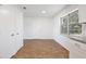 Bright kitchen with white cabinets, wood-look tile flooring, a double door closet and granite countertops at 1228 Padgett Cir, Lady Lake, FL 32159