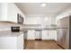Modern kitchen with stainless steel appliances, granite countertops, white cabinets and wood-look tile flooring at 1228 Padgett Cir, Lady Lake, FL 32159