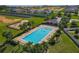 Aerial view of the community pool and playground, surrounded by lush green space and many houses at 124 Juno Dr, Groveland, FL 34736