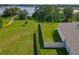 Aerial view of the expansive backyard with lush landscaping, a walking path, and access to community amenities at 124 Juno Dr, Groveland, FL 34736