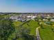 An aerial view shows nearby homes and common green areas, allowing potential buyers to understand the neighborhood at 124 Juno Dr, Groveland, FL 34736