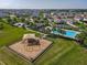 Aerial view of the community playground, houses, and green space in a well-maintained neighborhood at 124 Juno Dr, Groveland, FL 34736