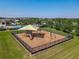 Aerial view of the community playground with a shade cover and equipment surrounded by green lawns at 124 Juno Dr, Groveland, FL 34736