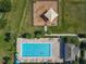 Aerial view shows community pool with cool blue water, playground with protective canopy, and lush green spaces at 124 Juno Dr, Groveland, FL 34736