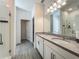 Modern bathroom with a double sink vanity, gray countertops, and a sleek glass-enclosed shower at 124 Juno Dr, Groveland, FL 34736