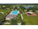 Aerial view of the community pool, playground, verdant landscaping, and sidewalks lined with palm trees at 124 Juno Dr, Groveland, FL 34736