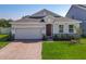 Charming single-Gathering home featuring brick driveway and two-car garage in a well-kept lawn at 124 Juno Dr, Groveland, FL 34736