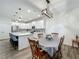 Open kitchen with white cabinets, island seating, stainless steel appliances, and adjacent dining area at 124 Juno Dr, Groveland, FL 34736